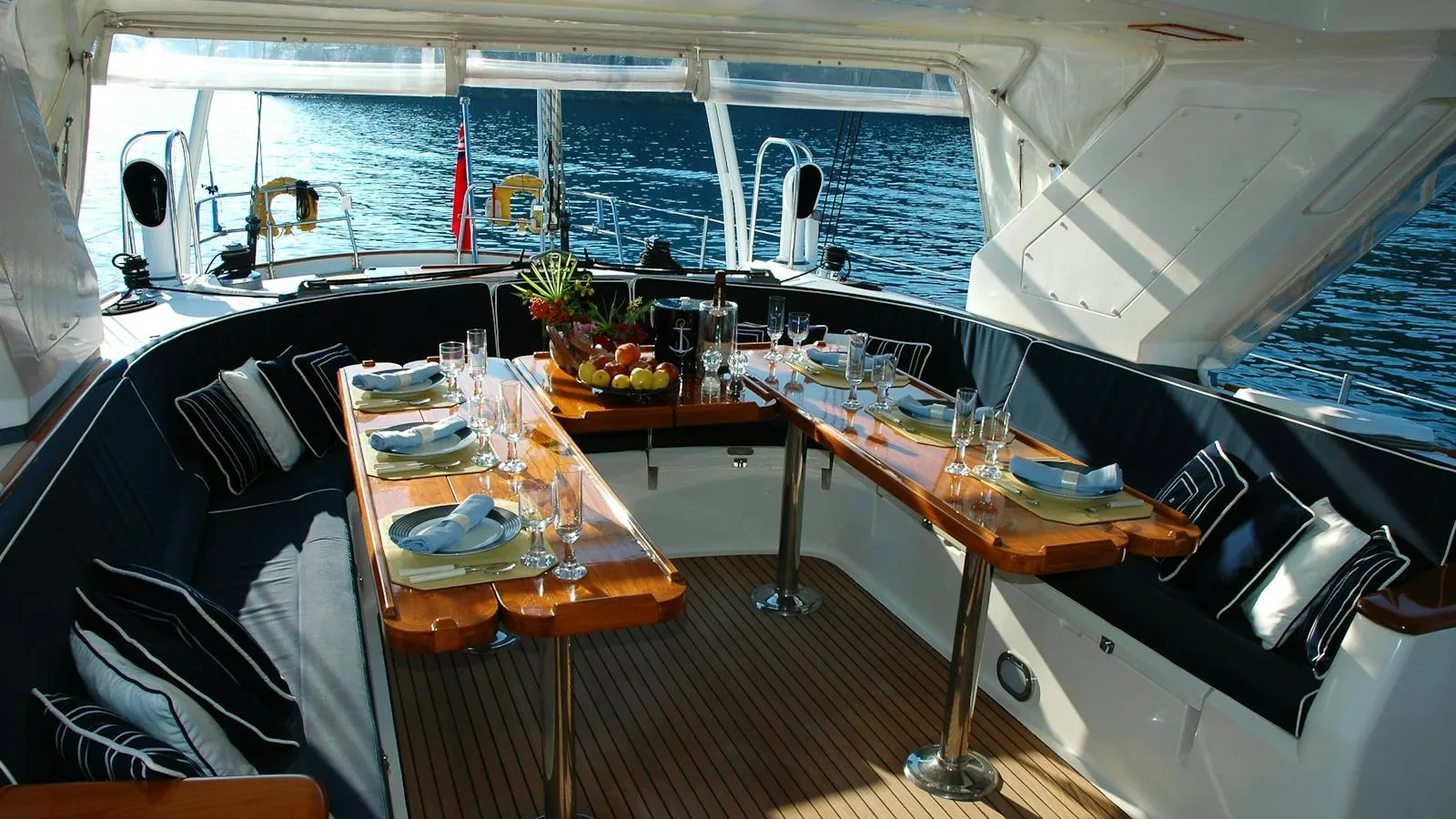 Yacht cockpit with teak dining table at sunset